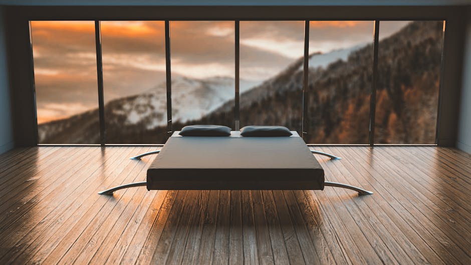 Minimalist bedroom with large windows offering a breathtaking mountain view during sunset